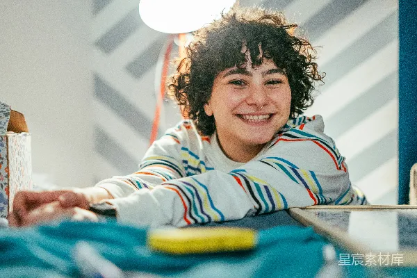 高清摄影 一个年轻男孩坐在桌子旁笑着。