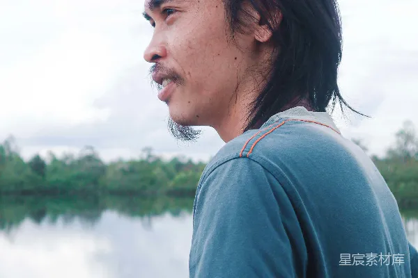 高清摄影 一个男人站在一片水域旁边
