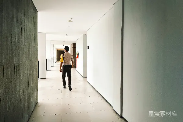 高清摄影 一个男人在两堵墙之间的长走廊中行走
