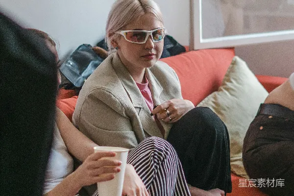 高清摄影 沙发上坐着一位女性，手中拿着一杯咖啡。