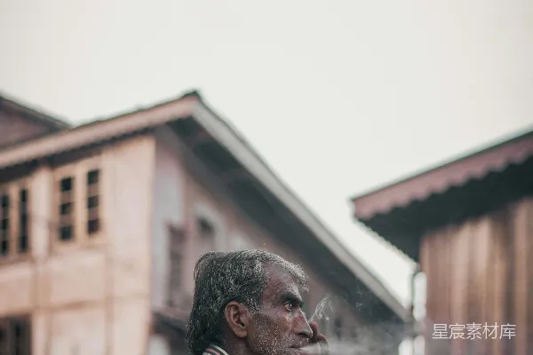 高清摄影 一个男人坐在车后部抽着香烟。