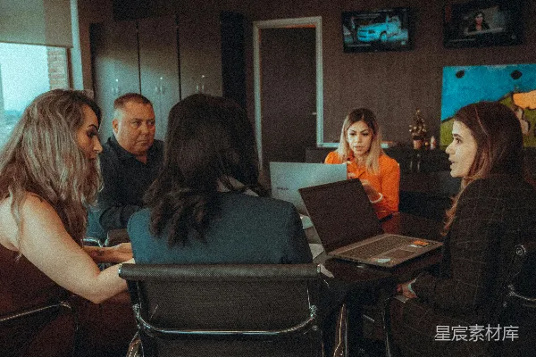 高清摄影 一群人在一张桌子周围坐着，每人面前有一台笔记本电脑。