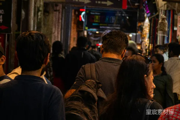 高清摄影 人群在一条繁忙、霓虹灯闪烁的大街上行走。