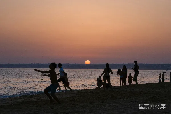 高清摄影 夕阳下人们享受海滩的轮廓