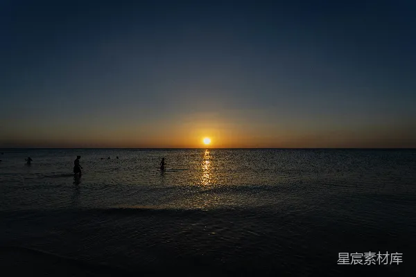 高清摄影 夕阳下的海洋，人们的剪影。