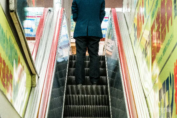高清摄影 穿蓝西装夹克的男人站在电梯上。