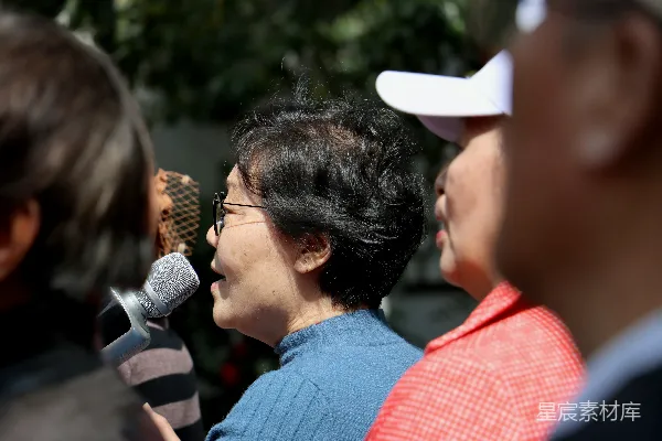 高清摄影 一个妇女手持麦克风站在一群人面前