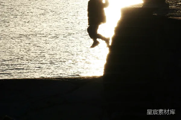 高清摄影 两个人靠在水边的太阳旁边形成剪影。