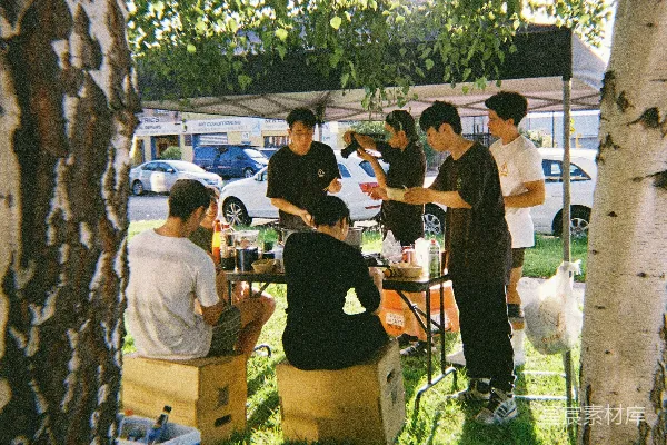 高清摄影 一群年轻人围坐在一张野餐桌旁