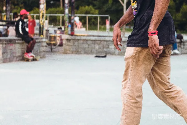 高清摄影 一个男人正在滑板旁边行走。