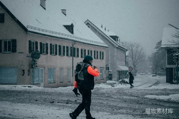 高清摄影 黑夹克黑裤子的人在白天走在覆盖着雪的路面上行走