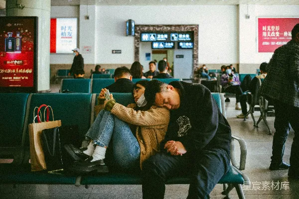 高清摄影 机场里，一名男性和一名女性坐在长凳上。
