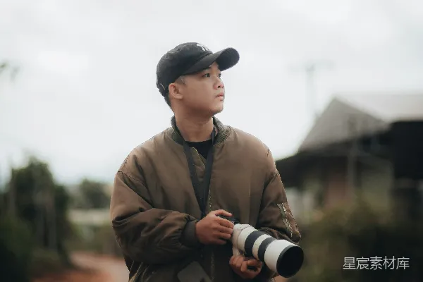 高清摄影 一个男人站在尘土路上手持相机。