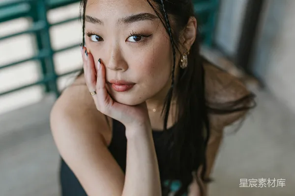高清摄影 一个女人坐在椅子上，用手捂住脸。