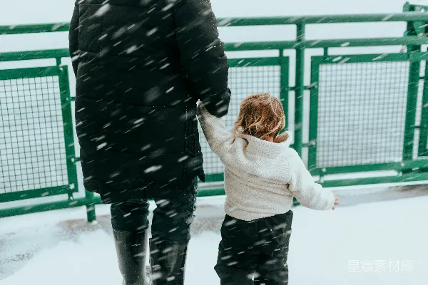 高清摄影 一个男人和一个孩子在雪地里行走