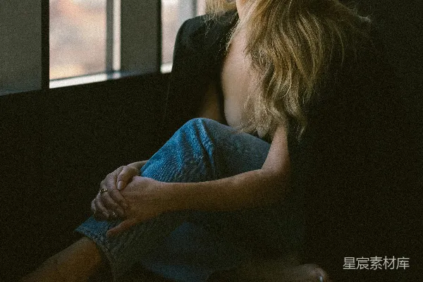 高清摄影 一个女人坐在地板上望着窗外。