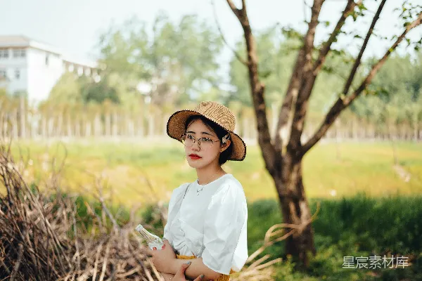 高清摄影 白色连衣裙穿着的女士戴着棕色帽子站在绿草旁的白天