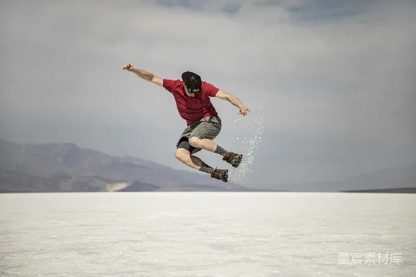 高清摄影 黑色上衣和黑色长裤的男人在白天在覆盖着积雪的地面上做特技。