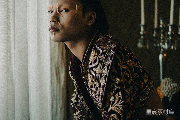 高清摄影 一个男人坐在一张床旁边，床靠近窗户。