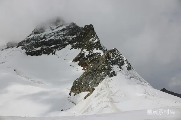 雪覆盖的山峰在云层笼罩下