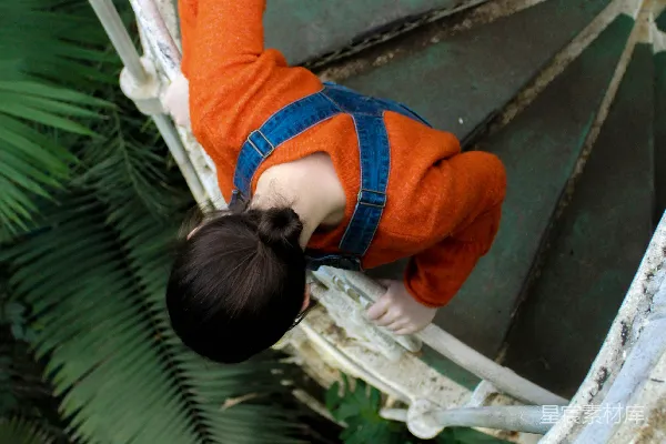 高清摄影 一个少年正在爬金属楼梯。