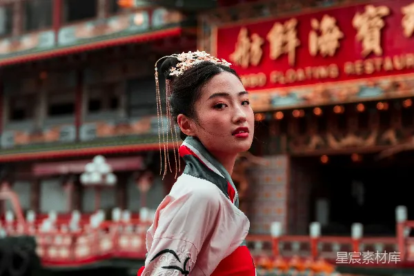 高清摄影 一个穿着红黑相间连衣裙的女人站在建筑物前。