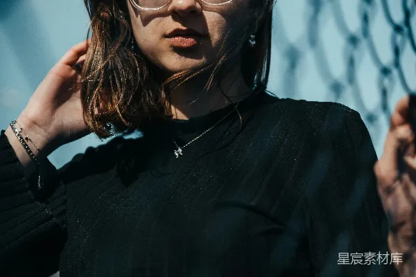 高清摄影 戴着眼镜的女人站在铁丝网旁边
