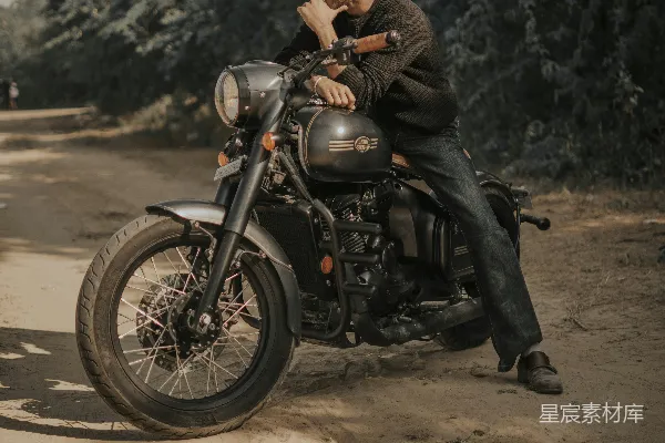 高清摄影 一个男人坐在一条土路上的摩托车旁