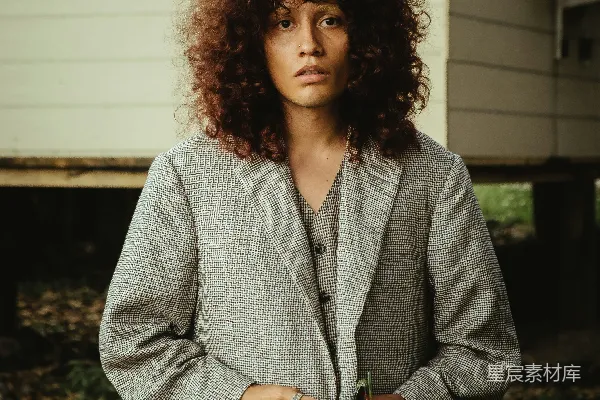 高清摄影 一头 curly 头发的女子站在房子前面