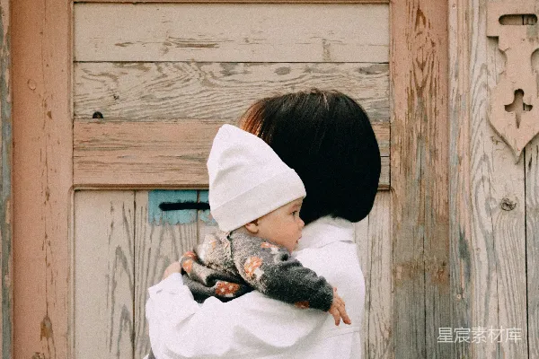 高清摄影 一个女人抱着一个小孩在怀里。
