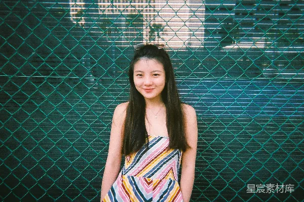 高清摄影 白蓝红条纹上衣的女人站在黑色金属围栏旁
