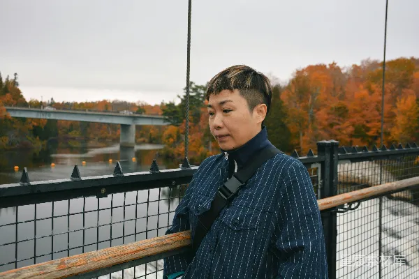 高清摄影 穿着黑色和白色格子长袖衬衫的男人站在靠近棕色木栏杆处的白天