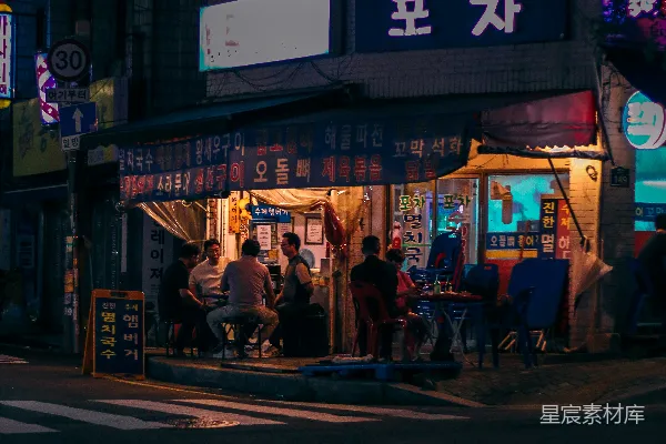 高清摄影 一群人在一家餐馆外面的夜晚坐坐。