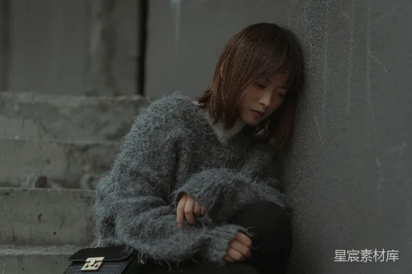 高清摄影 灰毛衣的女人坐在灰色的混凝土长凳上
