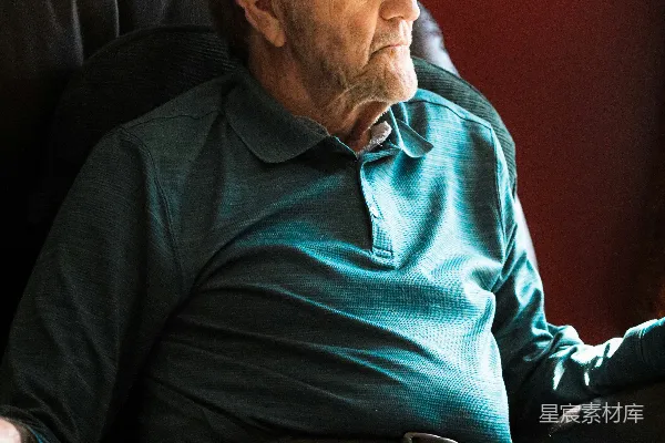 高清摄影 穿着绿色毛衣的男人坐在黑色的沙发上