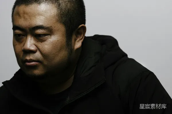 高清摄影 一个身穿黑色风衣的人盯着镜头看。