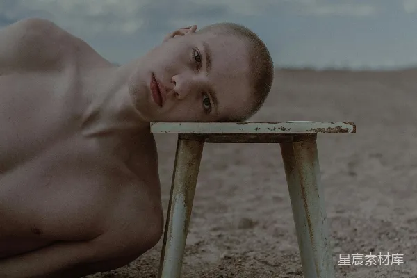 高清摄影 一个光着身子的男人躺在一张木桌上面。