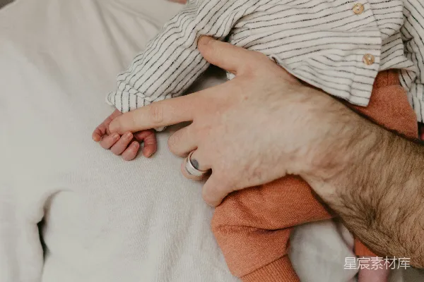 高清摄影 一个男人抱着一个婴儿在怀里。