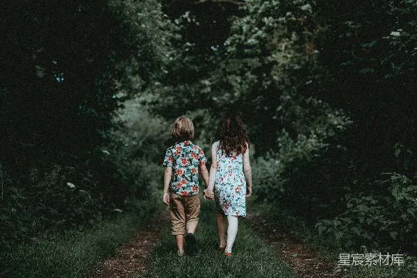 高清摄影 男孩和女孩手牵手走向树林。