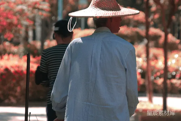 高清摄影 身穿蓝色衬衫、戴着棕色宽边帽的男人站在人行道上，白天拍摄