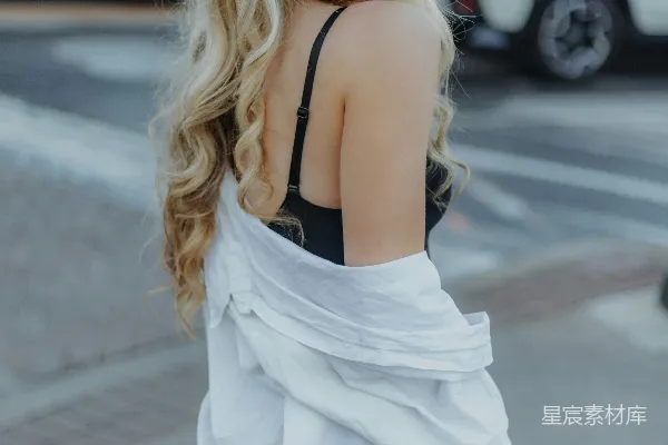 高清摄影 一个 blonde 头发的女子正在街上行走。