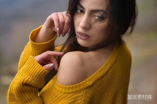 高清摄影 一个穿着黄色毛衣的女人正在拍照。