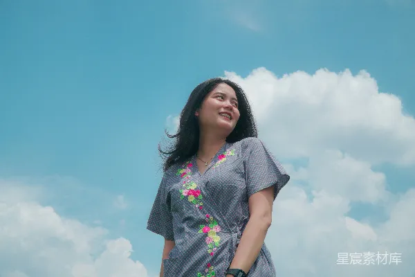 高清摄影 穿着灰色 floral 衬衫的女子在白色和蓝色的云朵下