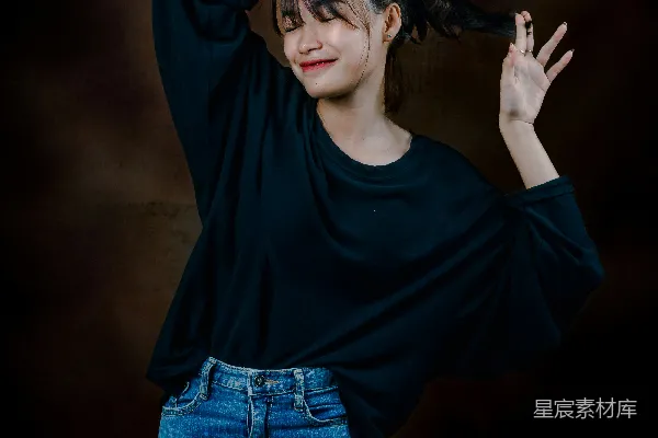 高清摄影 一个穿着黑色上衣和破洞牛仔裤的女人