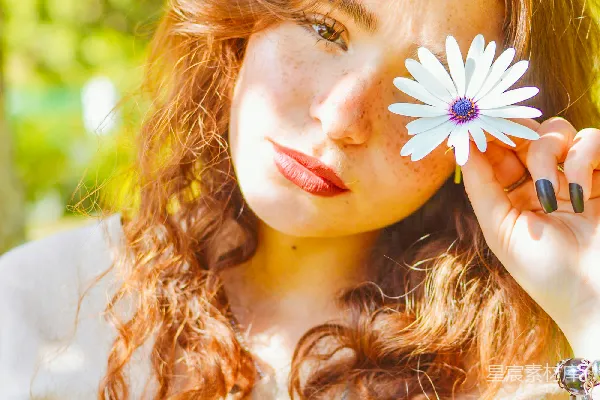 高清摄影 女士在阳光下拿着一朵雏菊靠近她的眼睛。