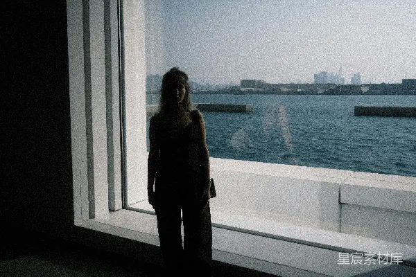 高清摄影 站在窗户前的女人旁边有一片水域。