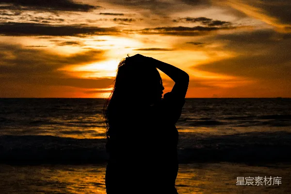 高清摄影 夕阳下的海滩上站立着一名妇女