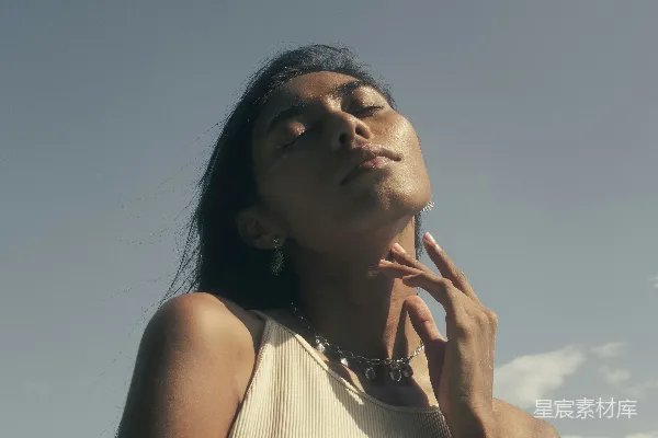 高清摄影 一个穿白色连衣裙的女人正在打电话。