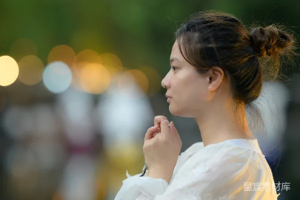 高清摄影 一个穿着白色连衣裙的女人站在街道上