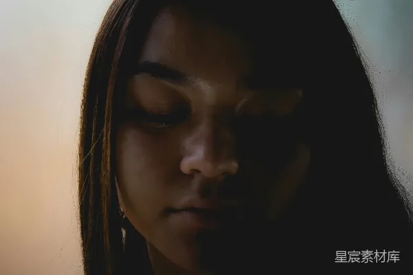 高清摄影 一个女人低头看着她的手机。